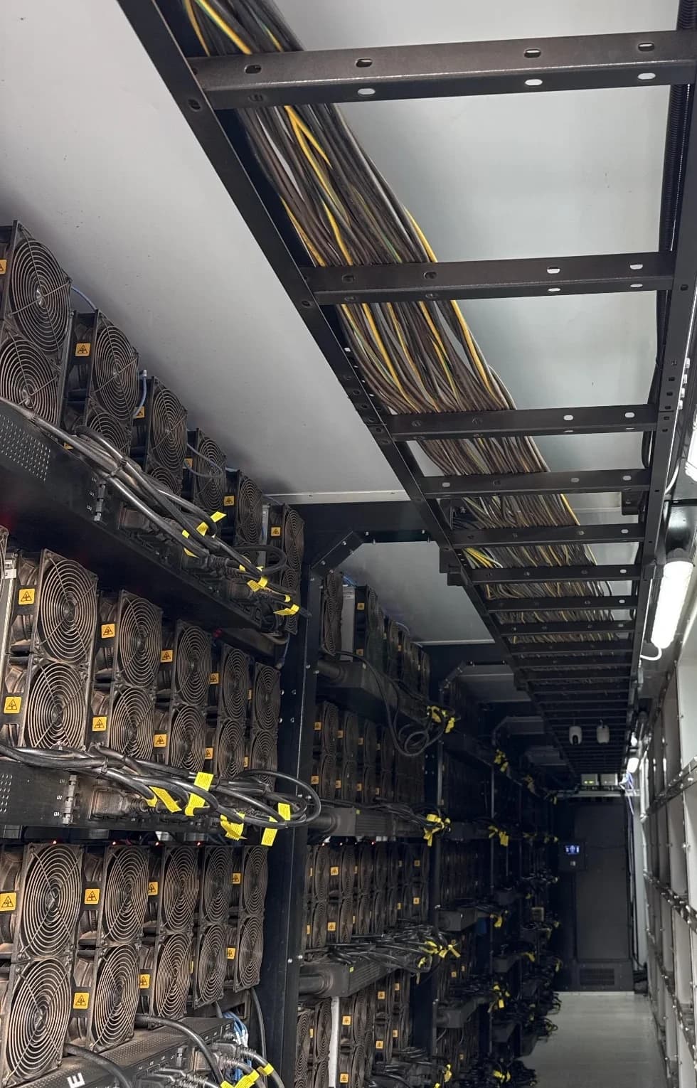 Interior do contêiner com fileiras de equipamentos ASIC