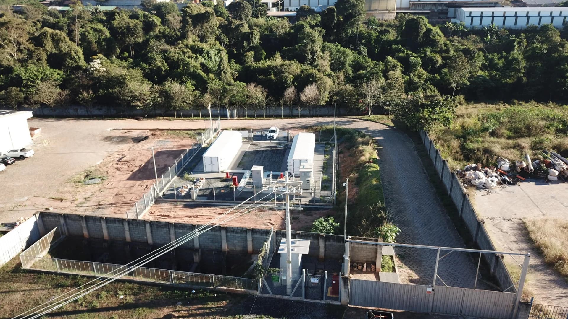 Vista geral aérea da instalação com contêineres e equipamentos elétricos